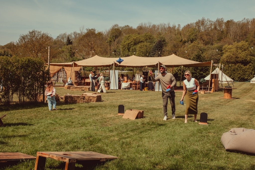 Open stretch canopy on grass with festoon lighting at an outdoor event
