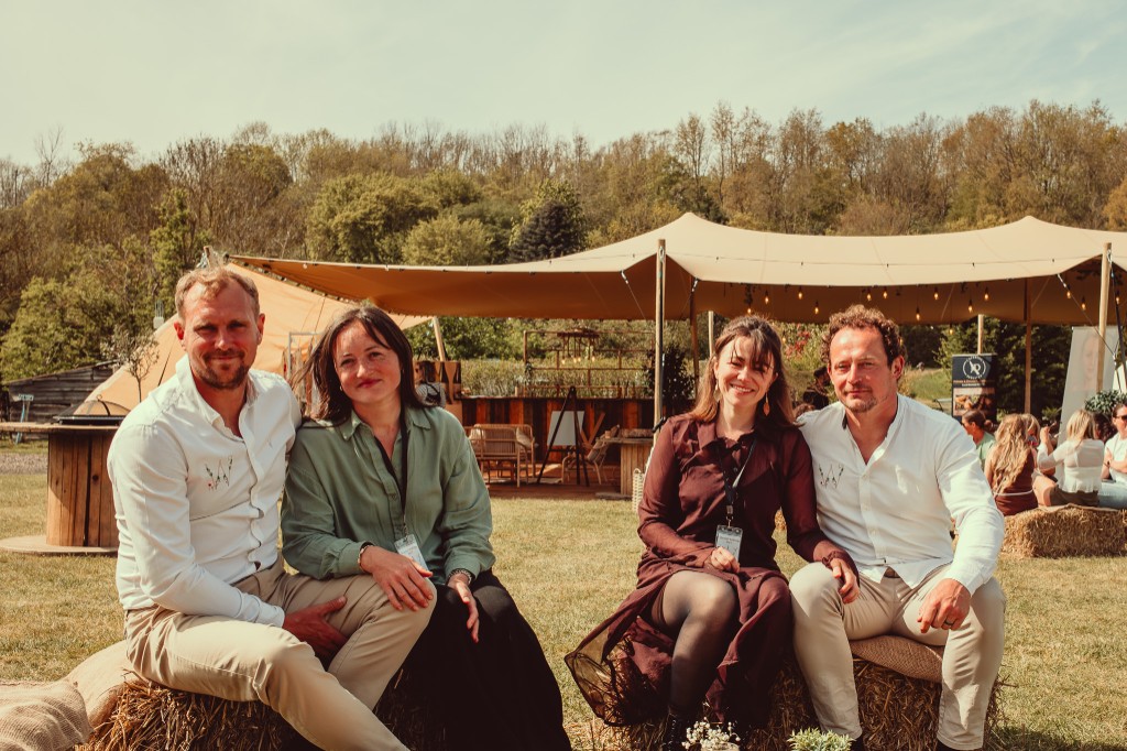 The Woodhill team sitting together on hay bales in front of a stretch tent